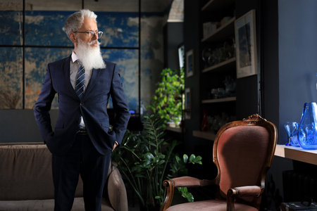 Stylish bearded man in a suit standing in modern office