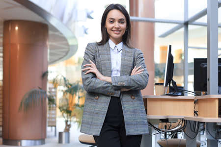 Attractive businesswoman standing near desk in the office