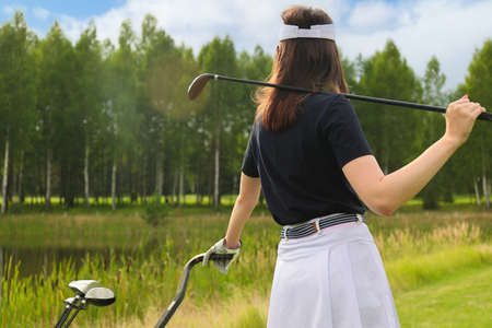 Young woman on golf course, back viewの写真素材
