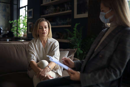 Professional middle aged psychologist conducting a consultation.の写真素材