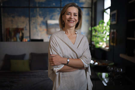 Confident stylish european middle aged woman standing at workplace, executive leader manager looking at cameraの写真素材