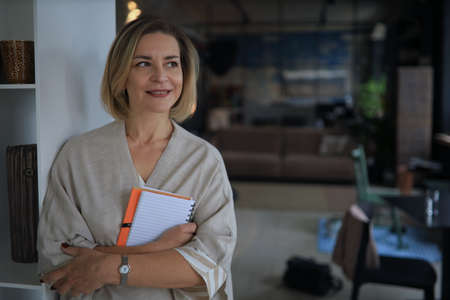 Confident stylish european middle aged woman standing at workplace, executive leader managerの写真素材