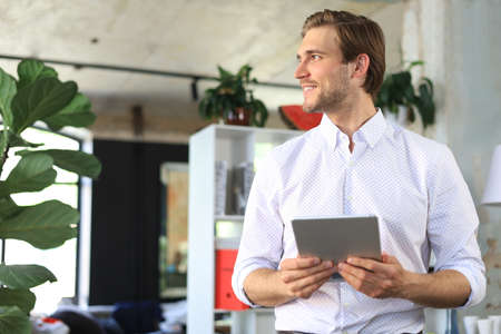 Handsome businessman using his tablet in the office