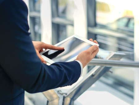 Midsection of businessman using digital tablet in office