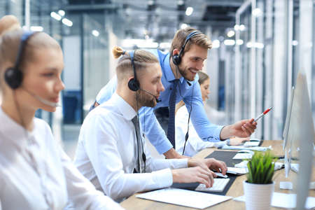 Phone operator working at call centre office helping hiss colleague.