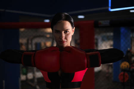 Young sports woman in tracksuit and putting hands together in red boxing glovesの写真素材