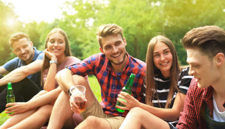 happy young friends enjoying picnic and eating.の写真素材
