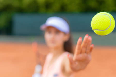 Professional female equipped tennis player beating hard the tennis ball with racquetの写真素材