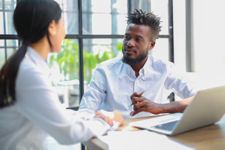 Two collegues discussing documents and other working moments in office