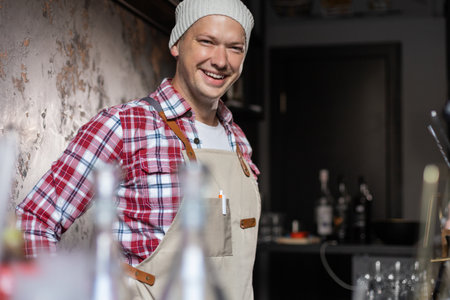 cafe owner. Pleasant delighted man sitting near the counter, smiling