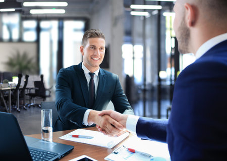 Business handshake. Two businessman shaking hands in the office.の写真素材