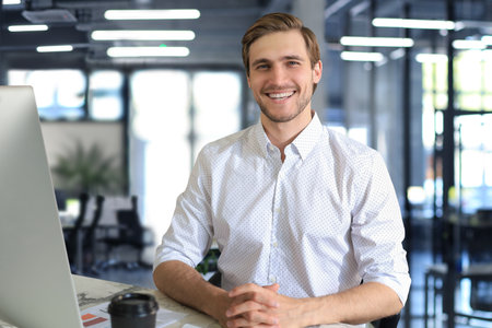 Young modern business man working using computer while sitting in the office.の写真素材