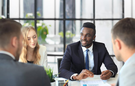 Business people in discussing something while sitting together at the table.