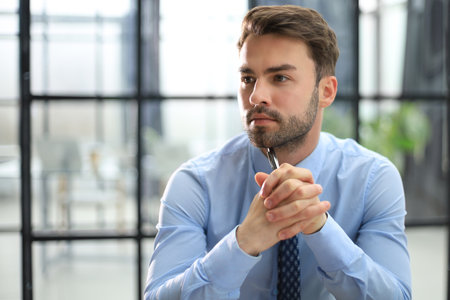 Portrait of handsome businessman sitting in officeの写真素材