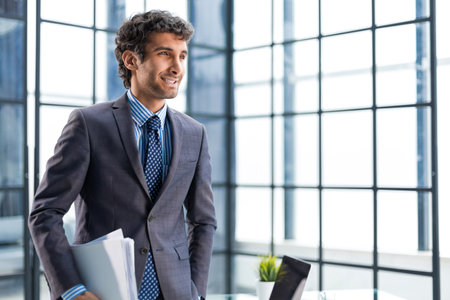 Young handsome businessman smiling in an office environment.の写真素材