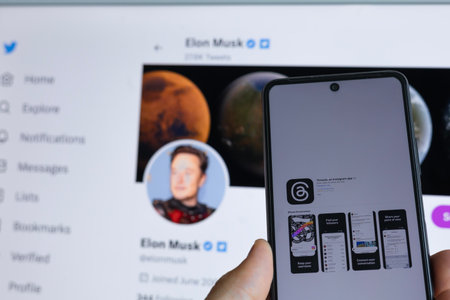 MINSK, BELARUS - July 07, 2023: A new app from Meta Platforms is a Twitter competitor called Threads. In the background of Elon Musks Twitter pageのeditorial素材
