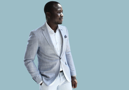 Portrait of a successful confident african businessman on blue background.の写真素材