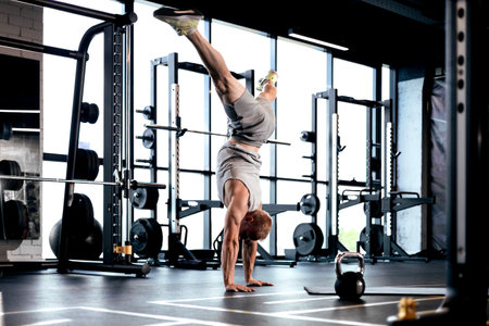 Strong man walking on hand during crossfit training in fitness club