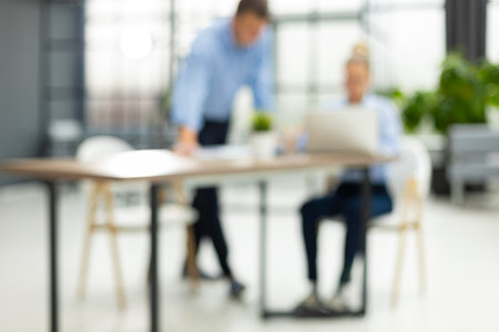 Two young businesspeople using a digital tablet while standing in a boardroom. Blurred.の写真素材