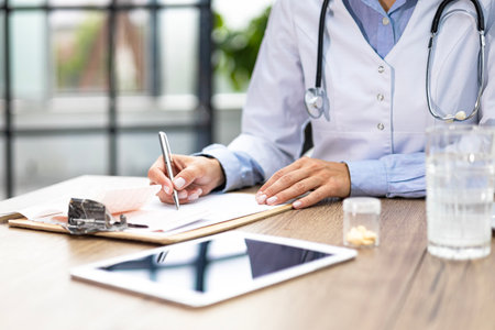 Medical doctor writing a recipe sitting at the desk.の写真素材