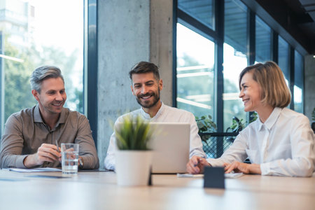 Happy business people executive team working at laptop having discussion at office meeting showing financial projectの写真素材