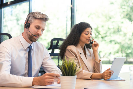 Happy young male customer support executive working in officeの写真素材