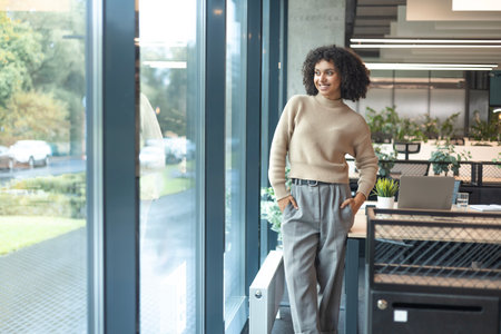 Smiling african businesswoman is standing in an office center.の写真素材