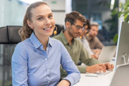 Attractive positive young businesspeople and colleagues in a call center office