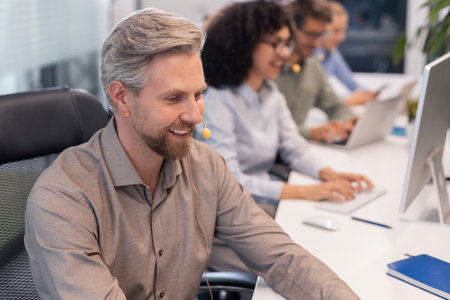 Attractive positive young businesspeople and colleagues in a call center office