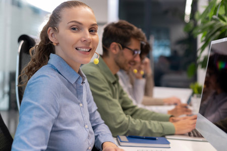 Professional customer support agent woman in assisting customers at call center office, with...