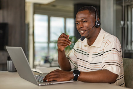 Concentrated african freelancer businessman using laptop for video conference, working remotely...