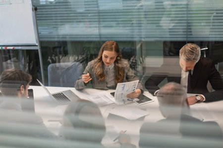 Business office with people in casual wear, with blurred bokeh background, view from glass wall.