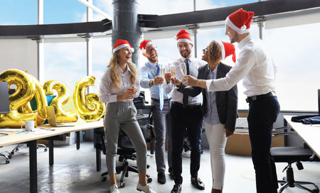 Business people are celebrating holiday in modern office drinking champagne and having fun in...