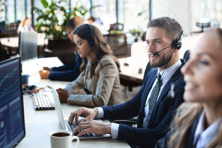 Portrait of call center worker accompanied by his team. Smiling customer support operator at work