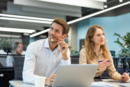 Handsome young businessman sitting confident in the office in front of his team.の写真素材