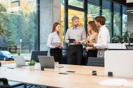 Group of business people standing together and discussing their work and projects, having a team...