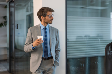 Smiling businessman manager executive standing in office.