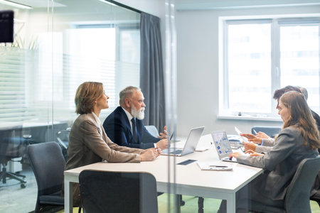 Creative business people, planning and meeting and brainstorming, ideas or strategy at office, view from glass wallの写真素材