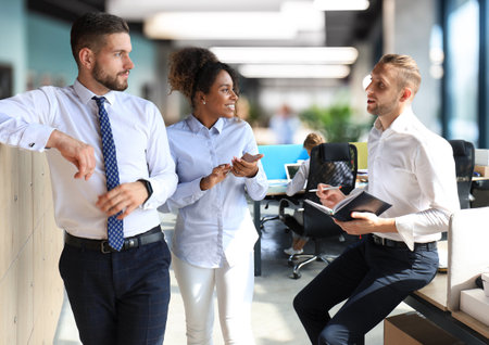 Group of young business people discussing something while working in the creative office.の写真素材