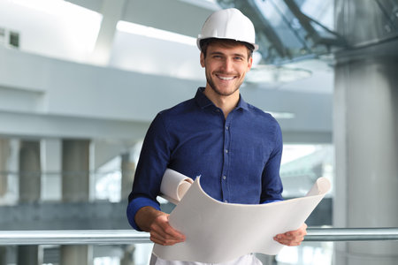 Shot of male architect wearing hardhat and inspecting new building