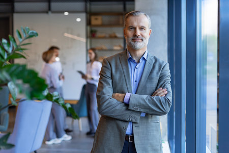 Confident pensive mature business man in modern office