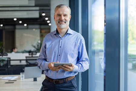 Handsome businessman using his tablet in the officeの写真素材
