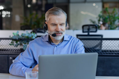 Male support service operator talking to customer sitting at desk.
