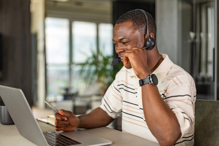 Concentrated african freelancer businessman using laptop for video conference, working remotely...