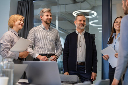 Successful businesspeople working in a coworking space working with laptop discussing strategy and business plan in modern office