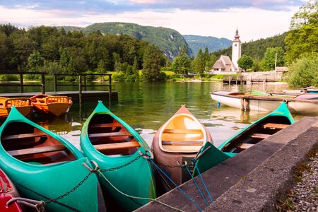 Bohinj Lake with boats and Church near Ribcev Laz, Julian Alps, Sloveniaの写真素材
