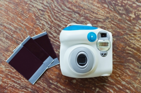instant camera with polaroid frames on wood background の写真素材