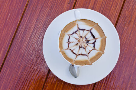 A white cup of coffee on wooden table.の写真素材