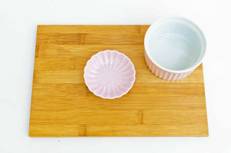 pink bowls on wooden cutting board isolated on white background.