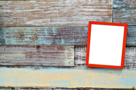 Red wooden frame hanging on a wooden board.の写真素材